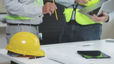 Genç Asyalı mimar ofiste tabletle çalışıyor.