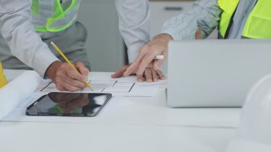 Ofiste inşaat projesinde çalışan mühendis ya da mimar. İnşaat mühendisi modern inşaatın planları üzerinde çalışıyor..