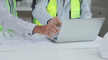 Genç mühendis bir evin planlarıyla çalışıyor, seçici bir odak noktası var.