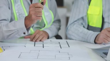 Ofisteki planlarla çalışan bir mimar