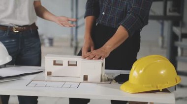 İnşaat alanının planı üzerinde çalışan mühendis ve mimar ekibinin dizüstü bilgisayarı ve planıyla ofiste yakın plan..