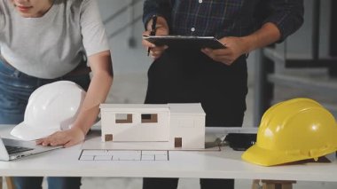 Dizüstü bilgisayar, mimar ve planlara sahip mühendis veya mühendis, inşaat modeli, mühendislik ve mimari, inşaat sahası.