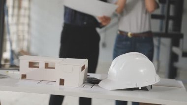 Ofisteki planlarla çalışan bir mimar