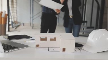 İnşaat alanında yeni ev planı üzerinde çalışan mühendis ya da mimar mühendisi.