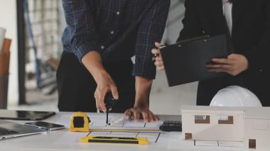 Ofiste ev modeli ve planlarıyla çalışan genç mühendis.