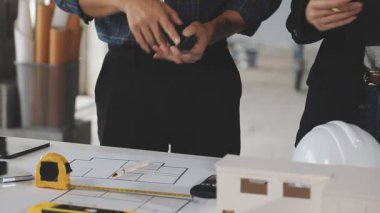 Mimar ve mühendis ofiste plan üzerinde çalışıyorlar.