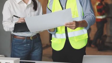 Asyalı genç iş adamları proje planı, inşaat sahasında çalışıyorlar