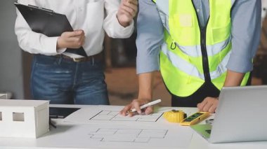 Mühendis ve mimar ofiste yeni projeyi tartışıyor