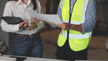 Ofiste tablet ve planlarla inşaat projesinde çalışan mimar.