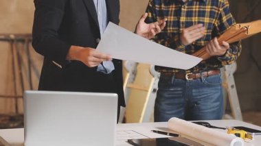 Genç mimar planlarla çalışıyor.