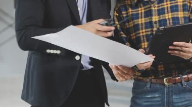 İş adamı ve iş kadını takım elbiseli ve evrakları ofiste..