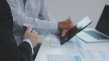 Takım elbiseli işadamları bir masada oturuyor ve ofiste çalışıyorlar. İş adamının fotoğrafı..