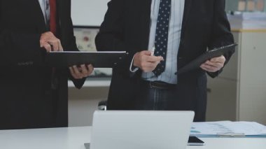 İş adamı ve iş adamı modern ofiste yeni projeyi tartışıyor