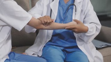 Asyalı doktor eli hastayı eline veriyor..