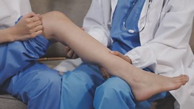 Kadın doktor bacağını muayene ediyor.