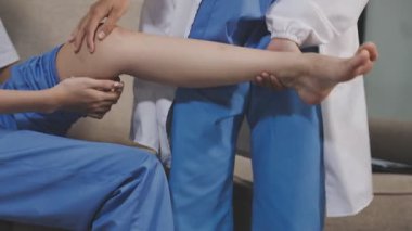 Kadın doktor bacak masajı yapıyor.