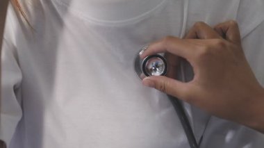 Doktor hastanın tansiyonunu ölçüyor.