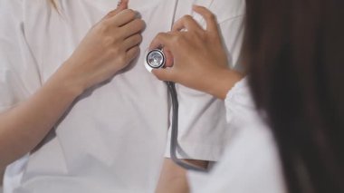 Doktor steteskopla nabzını kontrol ediyor.