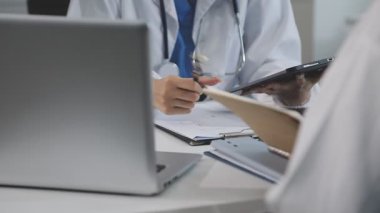 Kadın doktor hastanede tablet bilgisayar kullanıyor.