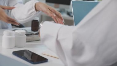 Hastane masasında boş ekranlı dijital tablet tutan doktor.