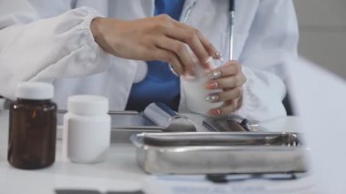 Doktor elinde bir şişe hap tutuyor.
