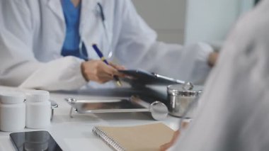 Yakın çekim. Beyaz önlüklü ve tıbbi maskeli doktorlar. Tıp üniformalı bir doktor. Doktor hapları gösteriyor.