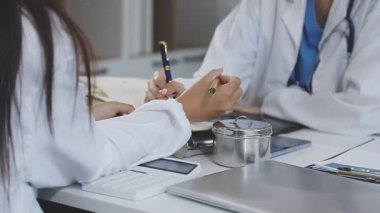 Doktor beyaz bir deftere yazıyor.