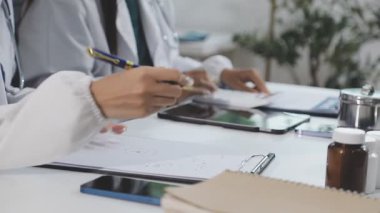 Modern bir ofisteki iş yerindeki kağıt tahtaya notlar yazan kadın doktor..