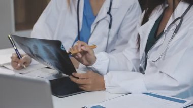 Üniformalı genç doktor ve hastane önlüğü bilgisayarda çalışıyor.