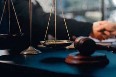 Hukuki bir duruşma sırasında ön planda adalet ve tokmak ile anlaşmaya varan iki avukat el sıkışıyor.