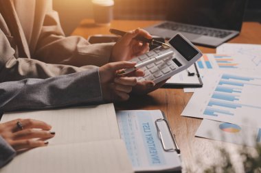 Group of confident business people point to graphs and charts to analyze market data, balance sheet, account, net profit to plan new sales strategies to increase production capacity.