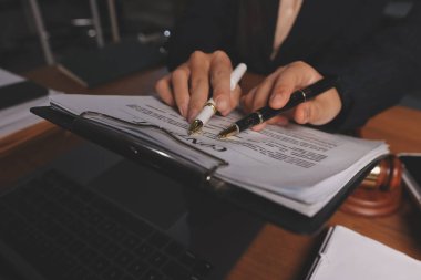 Attractive young lawyer in office Business woman and lawyers discussing contract papers with brass scale on wooden desk in office. Law, legal services, advice, Justice and real estate concept.