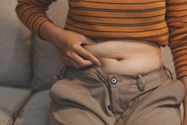 Şişman karnına dokunup sıkarken çekilmiş bir fotoğraf..