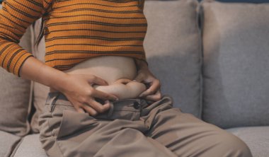 Şişman karnına dokunup sıkarken çekilmiş bir fotoğraf..