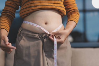 Şişman karnına dokunup sıkarken çekilmiş bir fotoğraf..