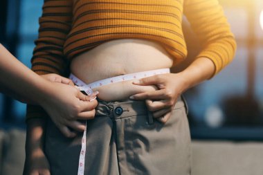 Şişman karnına dokunup sıkarken çekilmiş bir fotoğraf..