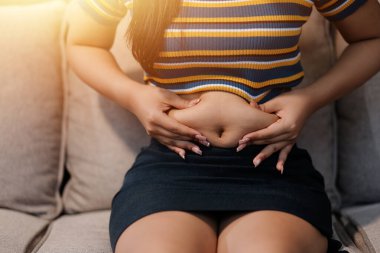 Şişman karnına dokunup sıkarken çekilmiş bir fotoğraf..