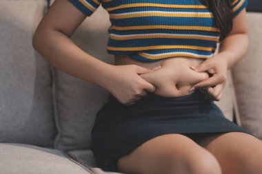 Şişman karnına dokunup sıkarken çekilmiş bir fotoğraf..