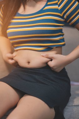 Şişman karnına dokunup sıkarken çekilmiş bir fotoğraf..