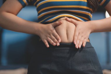 Şişman karnına dokunup sıkarken çekilmiş bir fotoğraf..