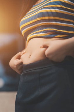 Şişman karnına dokunup sıkarken çekilmiş bir fotoğraf..