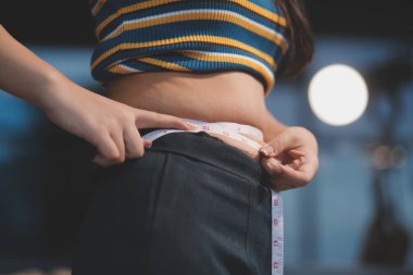 Şişman karnına dokunup sıkarken çekilmiş bir fotoğraf..