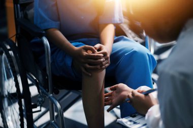 Kadın bir doktor, eklem iltihabı nedeniyle diz ağrısı olan yaşlı bir hastayı muayene eder. Hastaya iyileşme sürecinde yardım ediliyor, ağrı yönetimi ve hareket kabiliyetinin iyileştirilmesi üzerinde duruluyor..