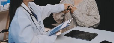 Doktor, yaşlı hastalar için solunum sistemini ve konsültasyonları inceleyen steteskop kullanın, sağlık kontrolünden bahsedin veya test sonuçlarını paylaşın, rahatlatın ve teşvik edin. Tıbbi tedavi ve uzmanlık kavramları, sağlık sigortası, emeklilik.