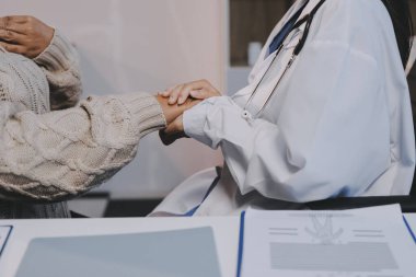 Doktor eli, kadın hastasına güven veriyor.