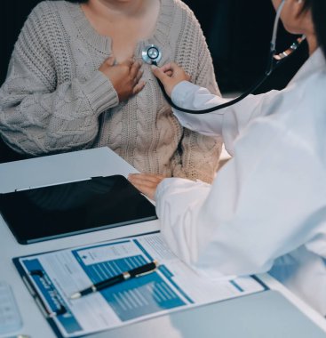 Doktor, solunum sistemini ve yaşlı hastalar için konsültasyonları inceleyen steteskop kullanın, sağlık kontrolü ya da test sonuçlarını paylaşın