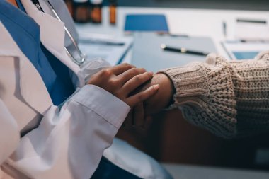 Doktor eli, kadın hastasına güven veriyor.