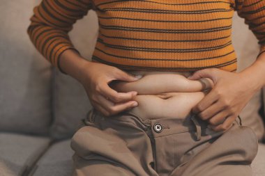 Şişman karnına dokunup sıkarken çekilmiş bir fotoğraf..