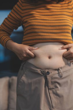 Şişman karnına dokunup sıkarken çekilmiş bir fotoğraf..