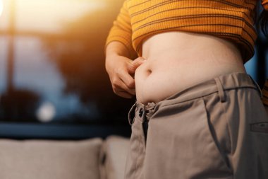 Şişman karnına dokunup sıkarken çekilmiş bir fotoğraf..